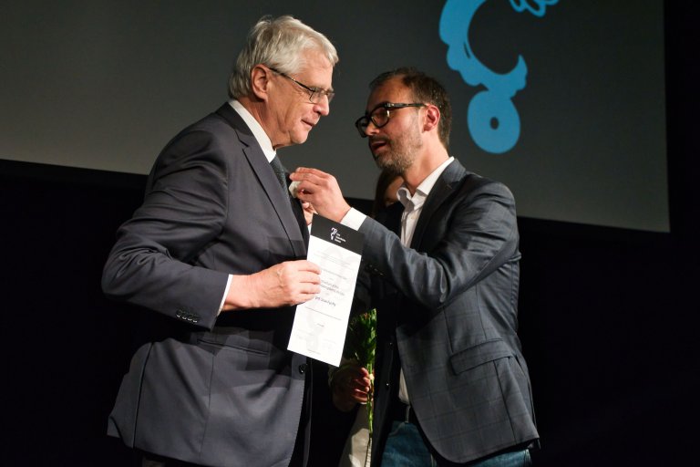 Václav Burian Award David Voda presents Prof. Jack Purchl with a brooch, which is part of the Václav Burian Award. Photo: Adéla Gehrová